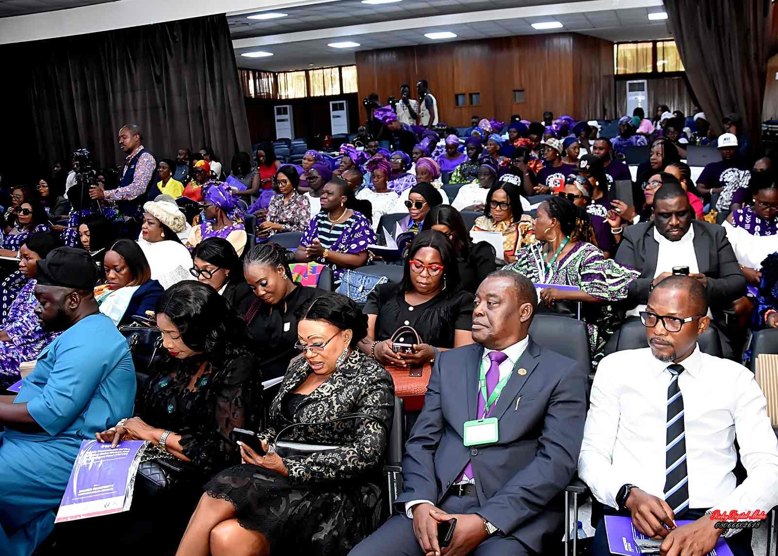 A wide view of the hall during the public presentation of the Women and Youth Impact Fund, attendees filling the seating.